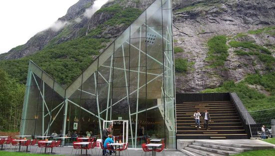 Sitteplasser foran Trollveggen Besøkssenter med et fjell i bakgrunnen
